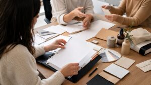 Marketer organizing a blank brand voice guide binder with colleagues in a workspace