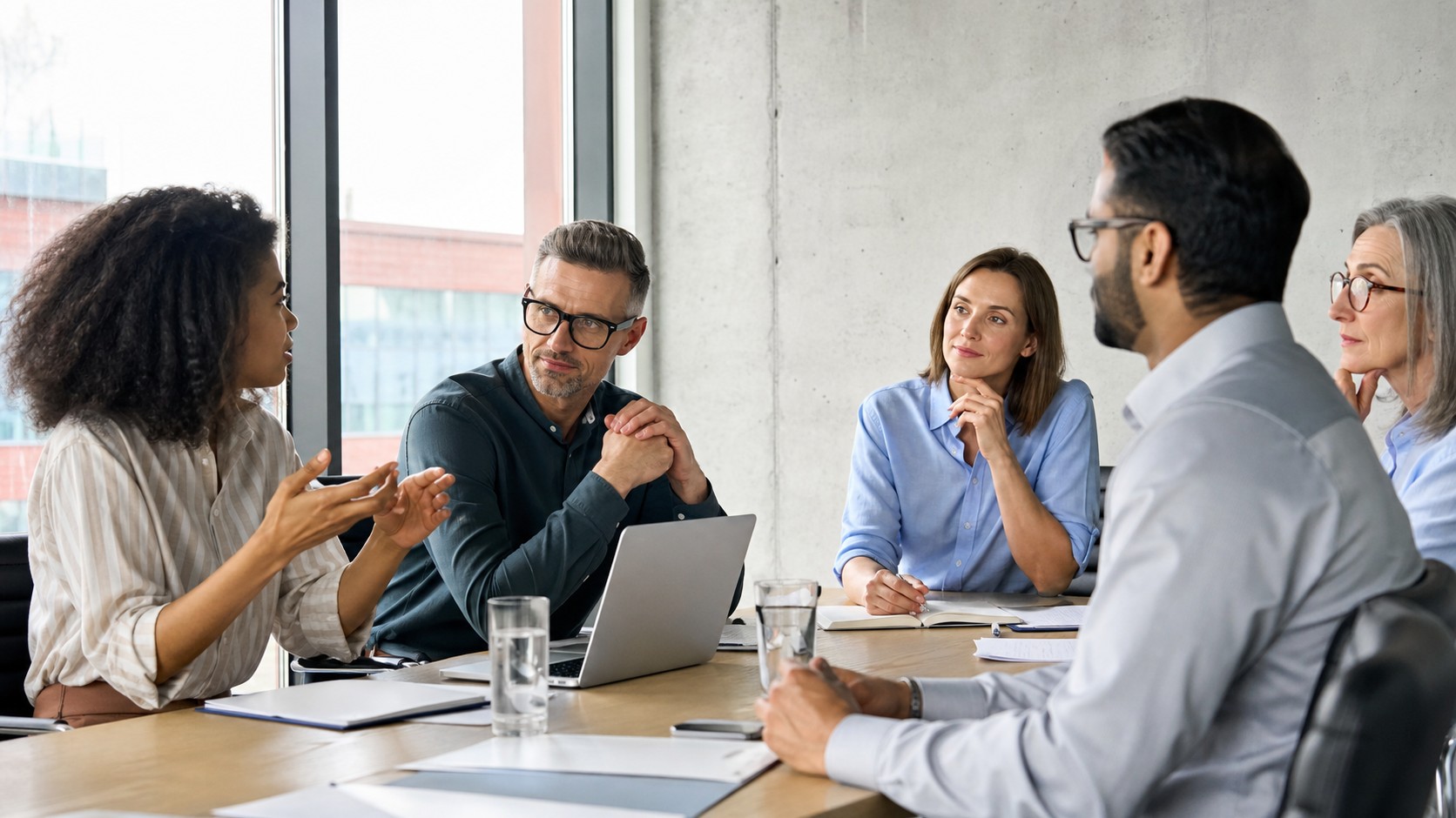Modern manager leading a thoughtful team discussion in a bright meeting room
